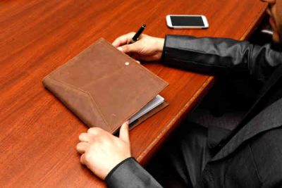 desk with a man hands and notebook with a pen in his hand